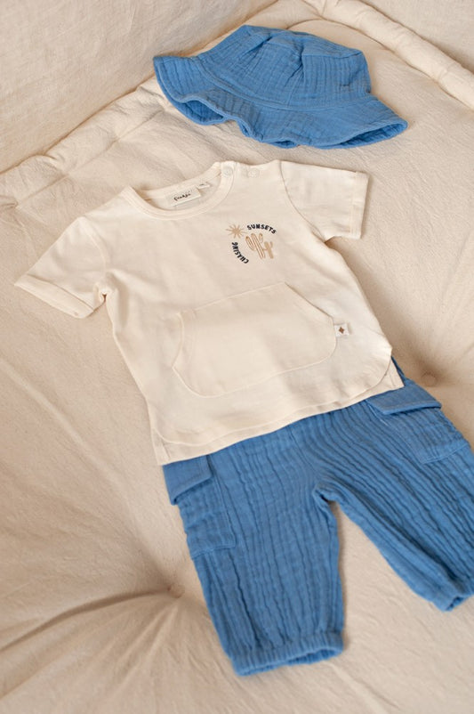 Afbeelding 2: Baby draagt blauw Feetje Ssiesta zonnehoedje buiten