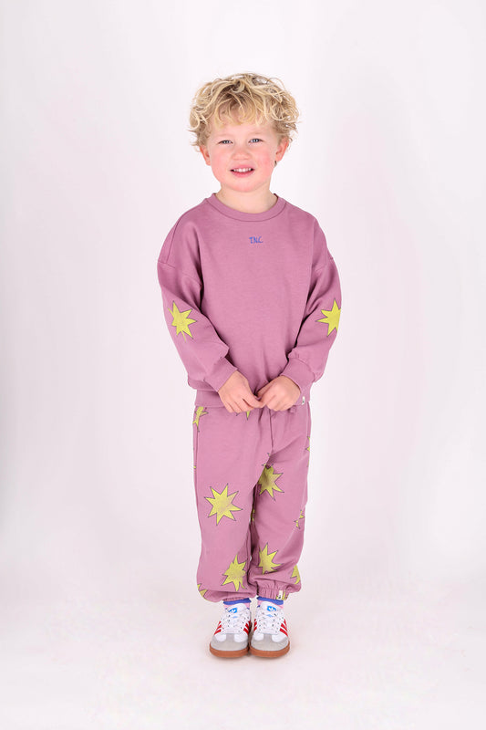 Meisje draagt roze kinderbroek met sterrenpatroon van THE NEW CHAPTER