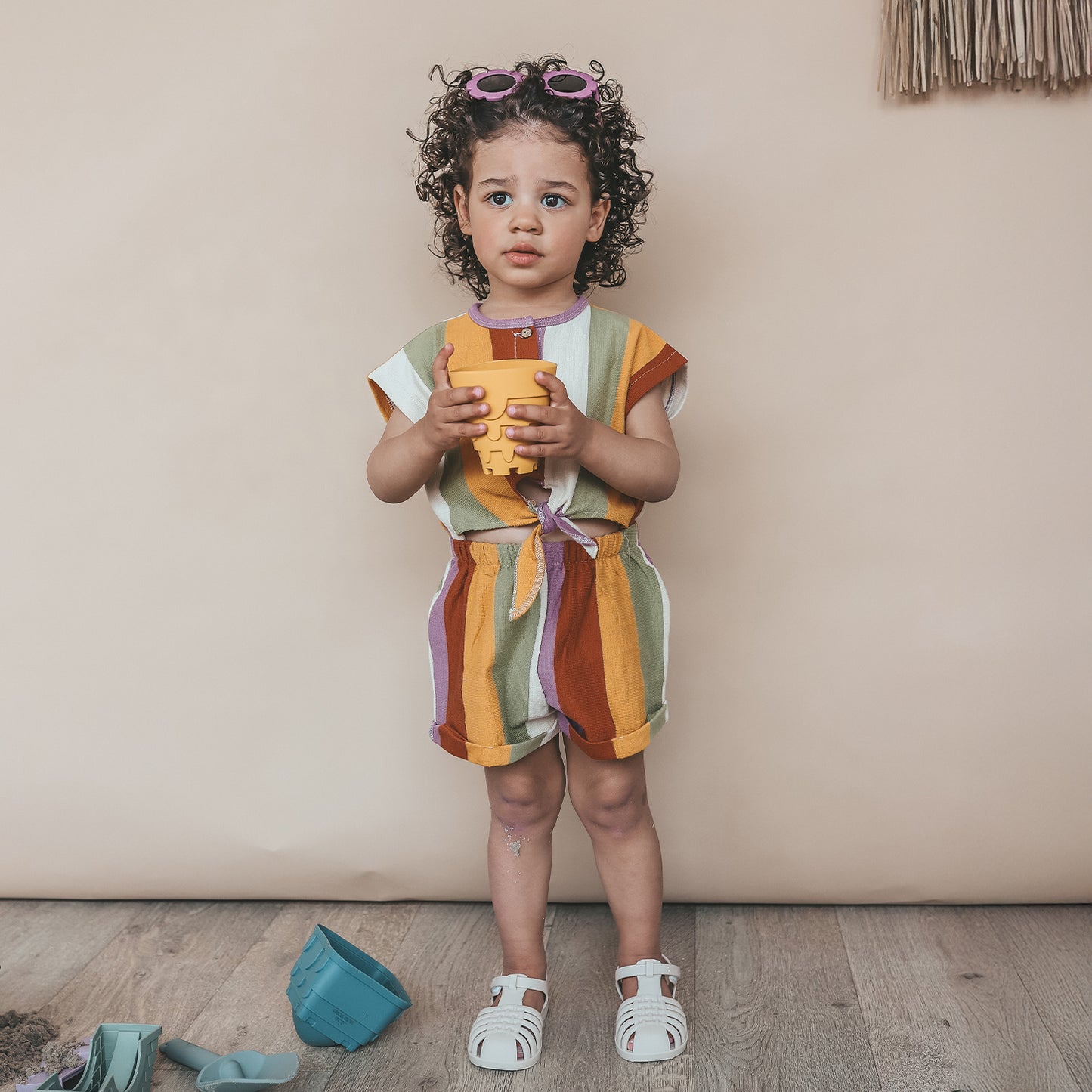 Meisje draagt SALTED STORIES gestreepte jumpsuit multicolor