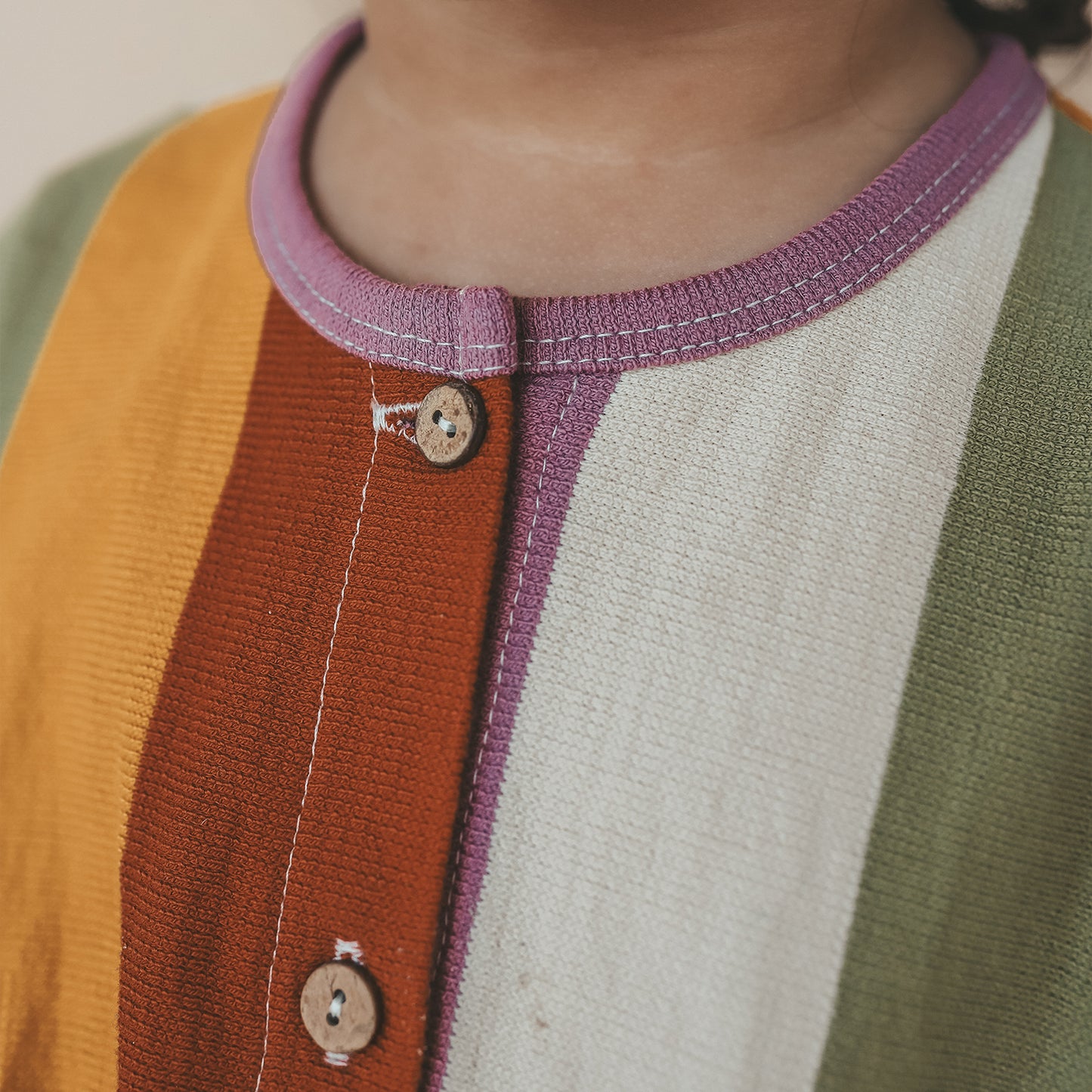 Close-up van SALTED STORIES jumpsuit met vrolijke multicolor strepen