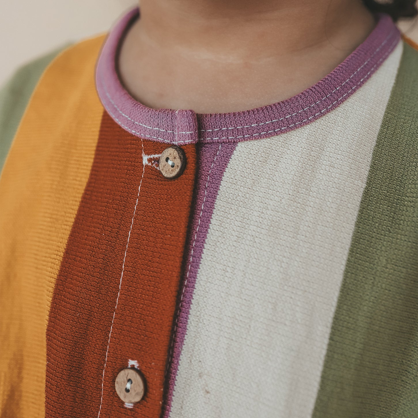 Close-up van SALTED STORIES jumpsuit met vrolijke multicolor strepen