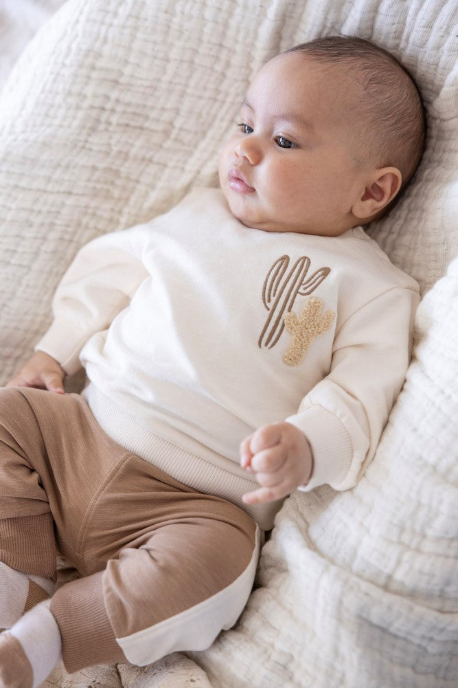 Baby draagt Feetje broekje Ssiesta camel met bijpassend shirt
