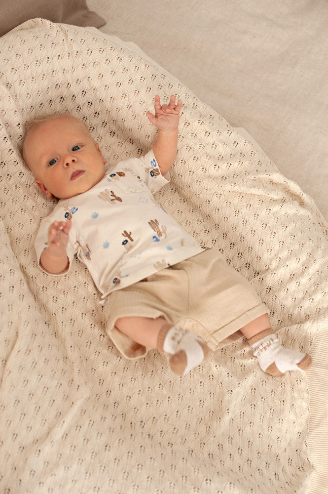 Baby draagt Feetje short Ssiesta sand met bijpassend shirt